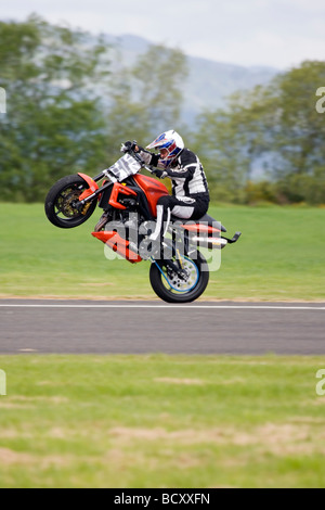 Kevin Carmichael Extreme Stunt ride su moto tirando impennata Foto Stock