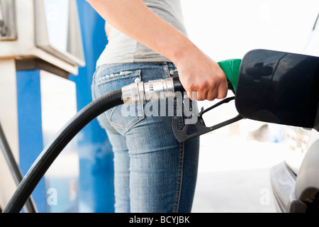 Giovane donna alla stazione di Gas Foto Stock