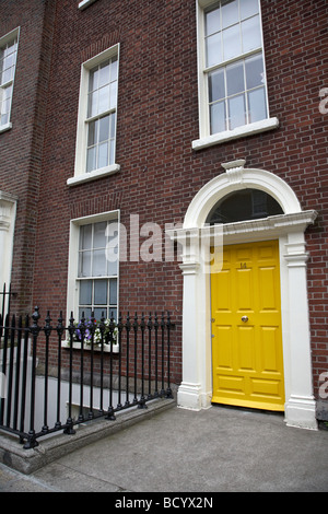 Dipinte di un giallo porta georgiana su un rosso mattone townhouse Merrion Square a Dublino Repubblica di Irlanda Foto Stock