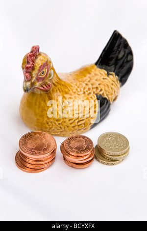 Le monete sono esposte accanto a una gallina di ceramica. Una gallina simile è stata utilizzata per la famiglia al posto del denaro in,nel British serie TV pane Foto Stock