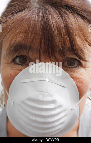 Donna di mezza età protettiva che indossa la maschera del filtro Foto Stock