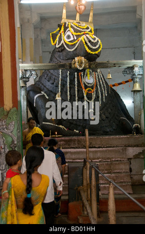 Le persone che frequentano Puja all'interno del tempio di Bull a Bangalore in India Foto Stock