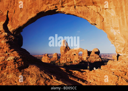 La torretta Arch visto attraverso la finestra del Nord presso sunrise con turisti Arches National Park nello Utah Stati Uniti d'America Settembre 2007 Foto Stock