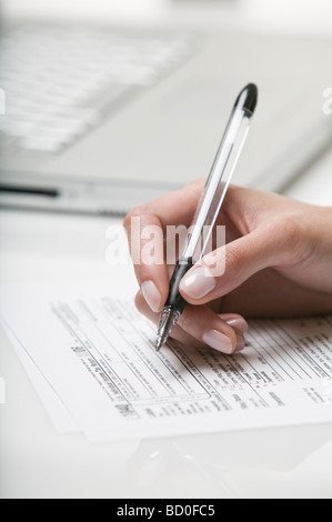 Donna di compilare un formulario fiscale Foto Stock