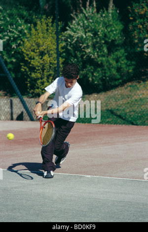 Ragazzo giocando a tennis Foto Stock