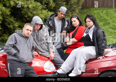 Gang di giovani seduti sulle vetture Foto Stock