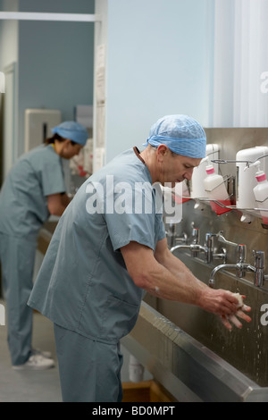 Il personale medico in scrubs lavaggio delle mani Foto Stock