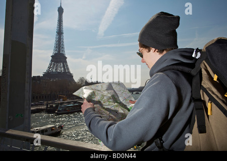 Uomo che guarda sulla mappa vicino a torre eiffel Foto Stock