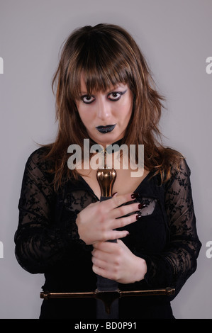 Ritratto in studio di una ragazza scuro con longsword Foto Stock