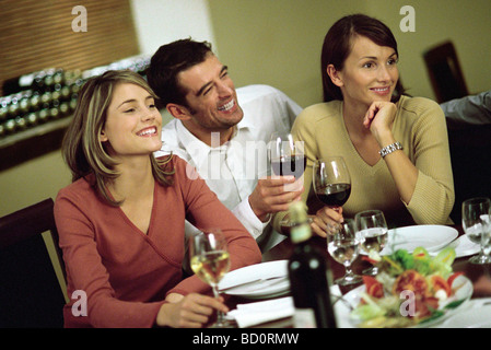 Uomo di vino con le donne al ristorante tabella Foto Stock