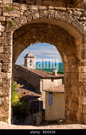 Chiesa campanile attraverso la porta medievale in pietra con Mont Ventoux oltre, Lacoste, Provenza, Francia Foto Stock