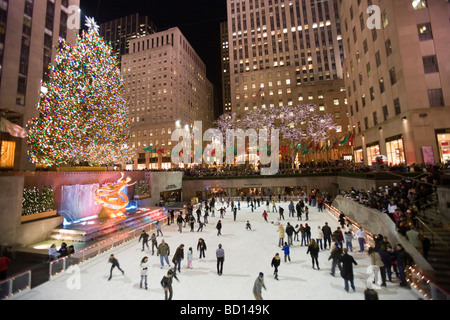 Pattinaggio sul ghiaccio in pista per il pattinaggio sul ghiaccio presso l albero di Natale al Rockefeller Center di notte. Foto Stock