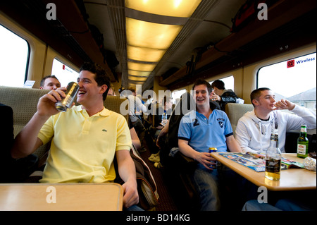 Bianchi Giovani maschi europei celebrare in un viaggio in treno. Foto Stock