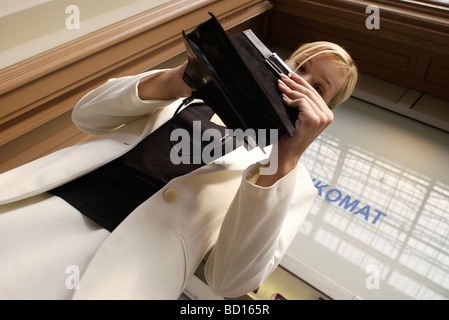 Ben vestito donna che guarda attraverso la borsa a basso angolo di visione Foto Stock