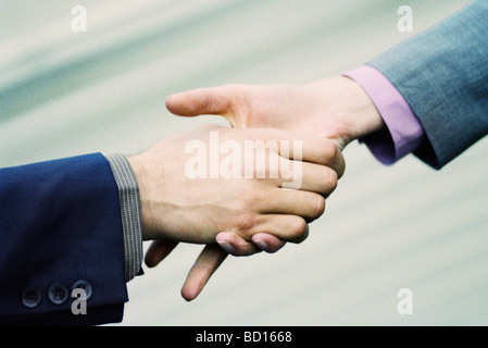 Handshake esitante tra i professionisti del settore Foto Stock