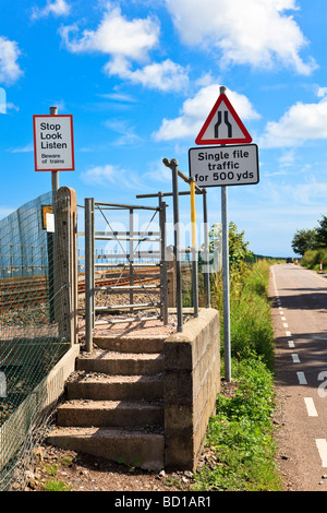 Cartelli di avvertimento sulla strada e la ferrovia che si incrociano in corrispondenza di Powderham l'incrocio ferroviario dà accesso alla spiaggia sul Fiume Exe Foto Stock