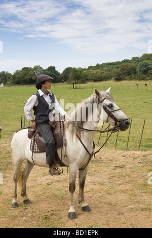 Gardian femmina montati su pony Camargue in campo prima di Bull Run presso il village fete vicino a Nimes Gard Francia Foto Stock