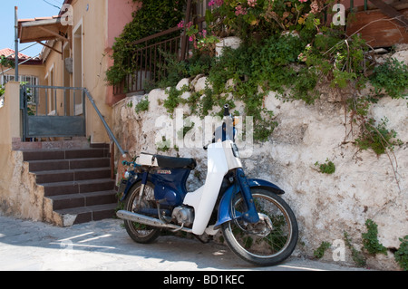 Scooter parcheggiato di fronte alla tipica casa cretese di Chania Creta Grecia Foto Stock