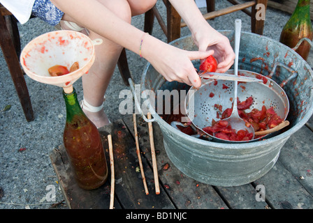 Dimostrazione del vecchio metodo per la creazione e la conservazione di concentrato di pomodoro e di imbottigliamento di esso Foto Stock