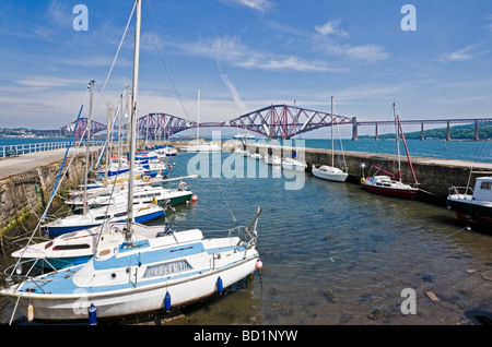 South Queensferry harbour con piacere le navi ormeggiate e Firth of Forth Rail Bridge in background. Foto Stock