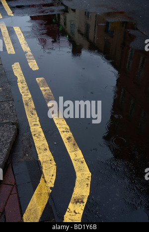 Doppio giallo linee su un lato umido street a Manchester Foto Stock