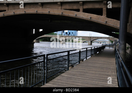 Il Grand Rapids riverwalk scende al di sotto di alcuni dei ponti attraverso il gran fiume Foto Stock
