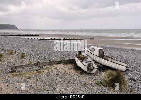 Due piccole imbarcazioni seduto sulla spiaggia Borth durate la marea arriva a. Foto Stock