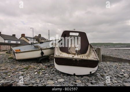 Due piccole imbarcazioni seduto sulla spiaggia Borth durate la marea arriva a. Foto Stock