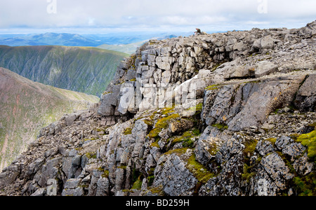 FORT WILLIAM INVERNESSSHIRE un camminatore solitario prende un meritato riposo dopo aver raggiunto la vetta rocciosa del Ben Nevis con su una chiara Foto Stock