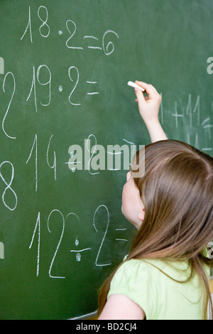 Ragazza scrivere sulla lavagna Foto Stock