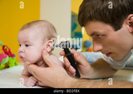 L'esame medico di neonati con otoscopio Foto Stock