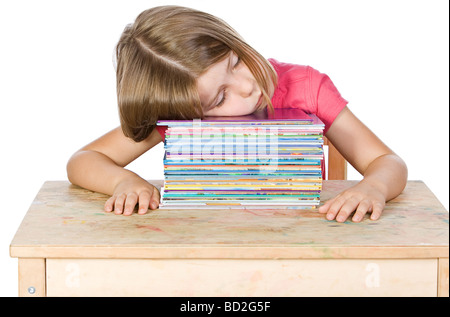 Colpo isolato di un giovane bambino ad addormentarsi sui suoi libri Foto Stock