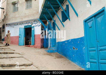 Scena di strada con uomo in jellaba davanti al suo negozio Larache Marocco Foto Stock