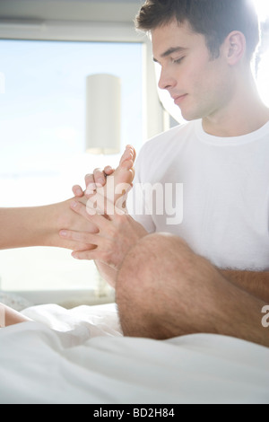 L uomo dando massaggio ai piedi Foto Stock