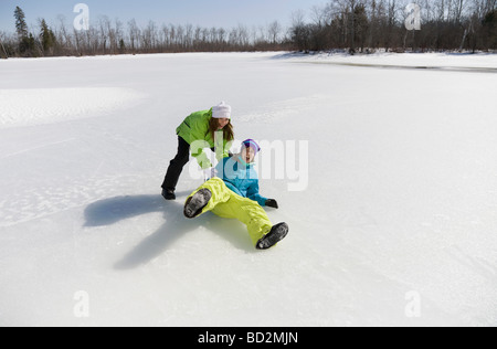 Due donne giocando sul lago ghiacciato Foto Stock