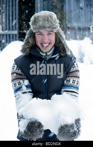 Giovane uomo nella neve sorridente Foto Stock