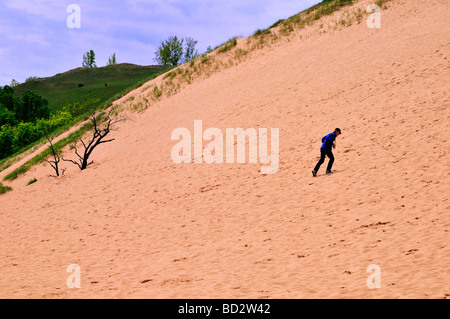 Un uomo escursioni su una duna di sabbia in Sleeping Bear Dunes National Lakeshore Foto Stock