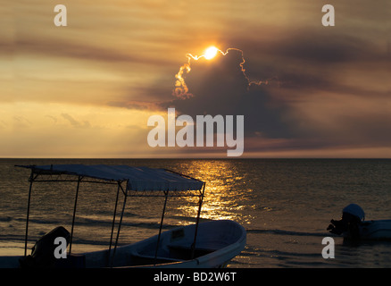 Un magnifico tramonto sull'Isola di Holbox, Quintana Roo Yucatán Penisola, Messico, barca da pesca Barche di nuvole con rivestimento in oro Foto Stock