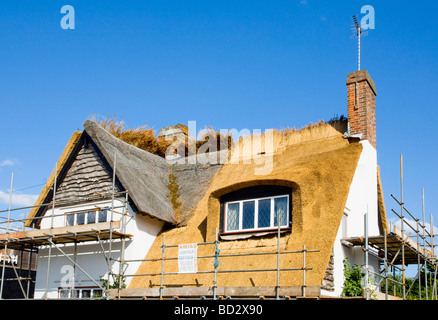 Il vecchio tetto di paglia nel processo di essere sostituito dal tetto di paglia di nuovo su un cottage in Walberswick, Suffolk, Inghilterra Foto Stock