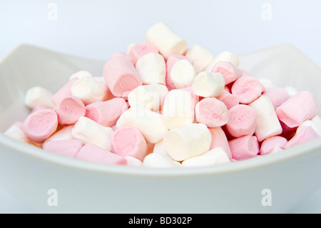 Studio shot di piccoli marshmallows in bianco ciotola contro uno sfondo bianco Foto Stock