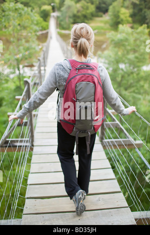 Donna escursionista su un ponte sospeso oscillante, Souris, Manitoba, Canada. Foto Stock