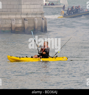 Fisherman sguazzare un ocean kayak attraverso l'ingresso del Giubileo Haven il RYS a Cowes Isle of Wight England Regno Unito Foto Stock