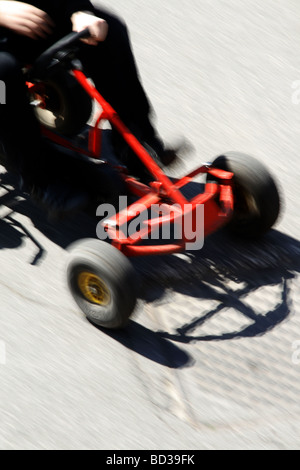 Ragazzo veloce di equitazione go kart auto in strada nel parco Foto Stock