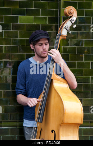 Busker al di fuori di un pub in Columbia Road, East London Foto Stock