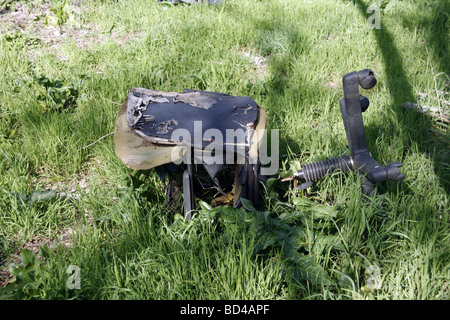 Un vecchio rotto la sedia da ufficio oggetto di pratiche di dumping nel campo Foto Stock