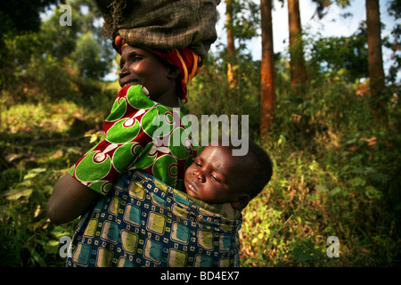 Donna e bambino sul bordo della Foresta impenetrabile di Bwindi Uganda sudoccidentale Foto Stock