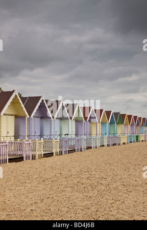 Fila di color pastello spiaggia capanne, Mersea Island, Essex, Regno Unito Foto Stock