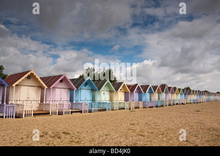 Fila di pastello spiaggia dipinte di capanne, Mersea Island, Essex, Regno Unito Foto Stock