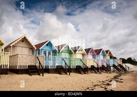 Fila di color pastello spiaggia capanne, Mersea Island, Essex, Regno Unito Foto Stock