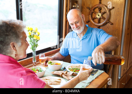 Coppia senior avente una cena romantica nella loro casa a motore Foto Stock